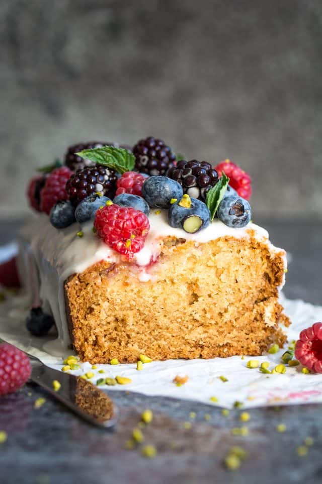 Vegan lemon and raspberry loaf cake, topped with raspberries, blackberries, and blueberries.