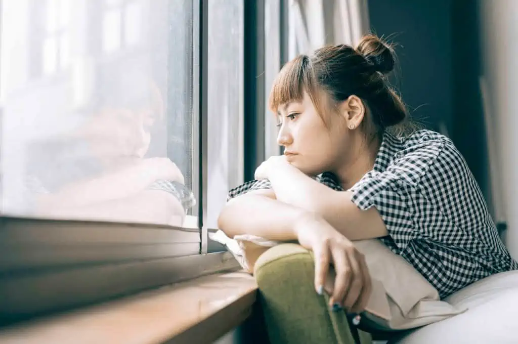 Woman looking out of a window - Life Without Social Media: Is It Better?