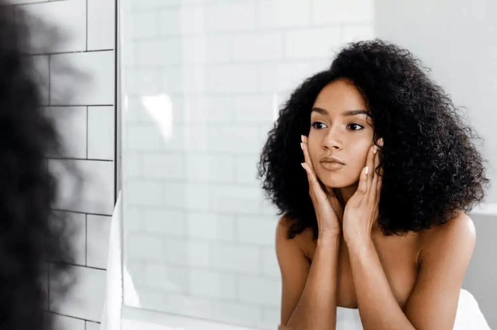 Woman looking in the mirror boosting her self esteem - Life Without Social Media: Is It Better?