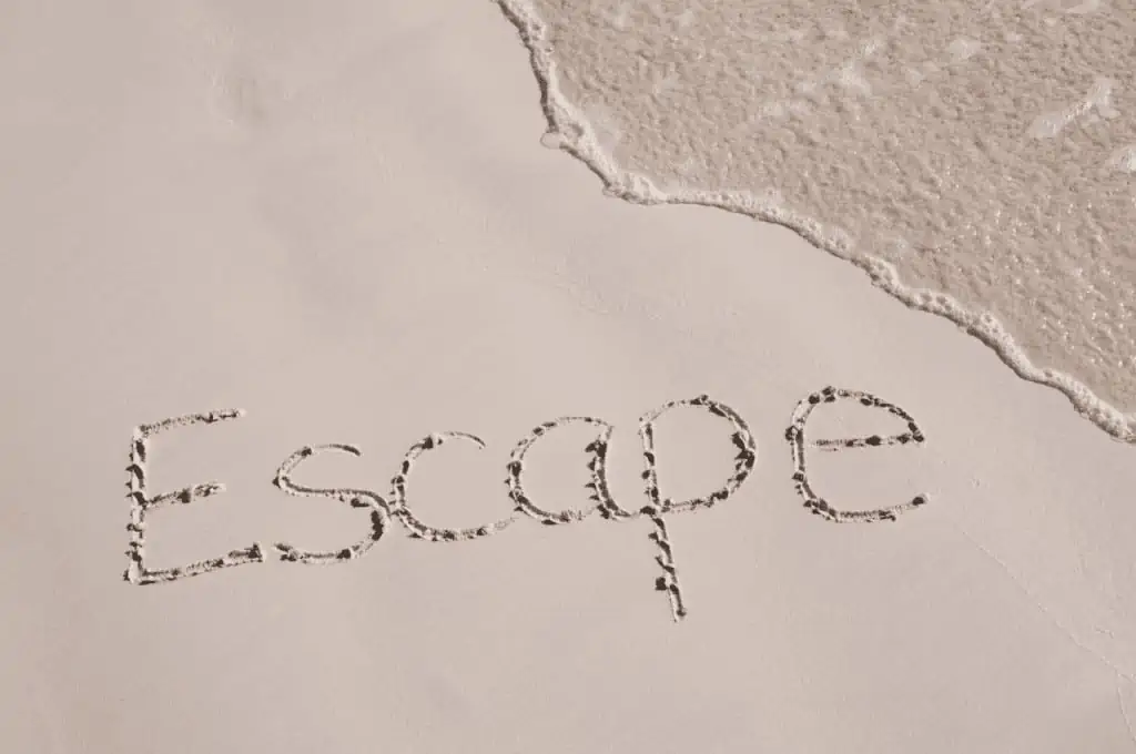 The word "escape" written in the sand of a beach - Life Without Social Media: Is It Better?