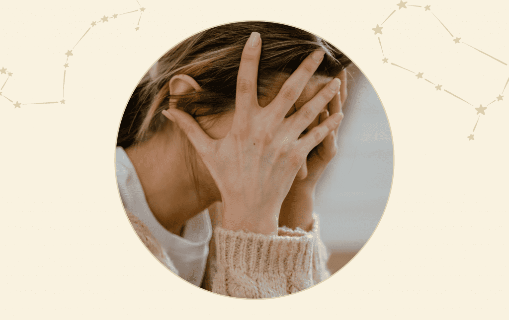 A woman holding her head in her hands, covering her face.