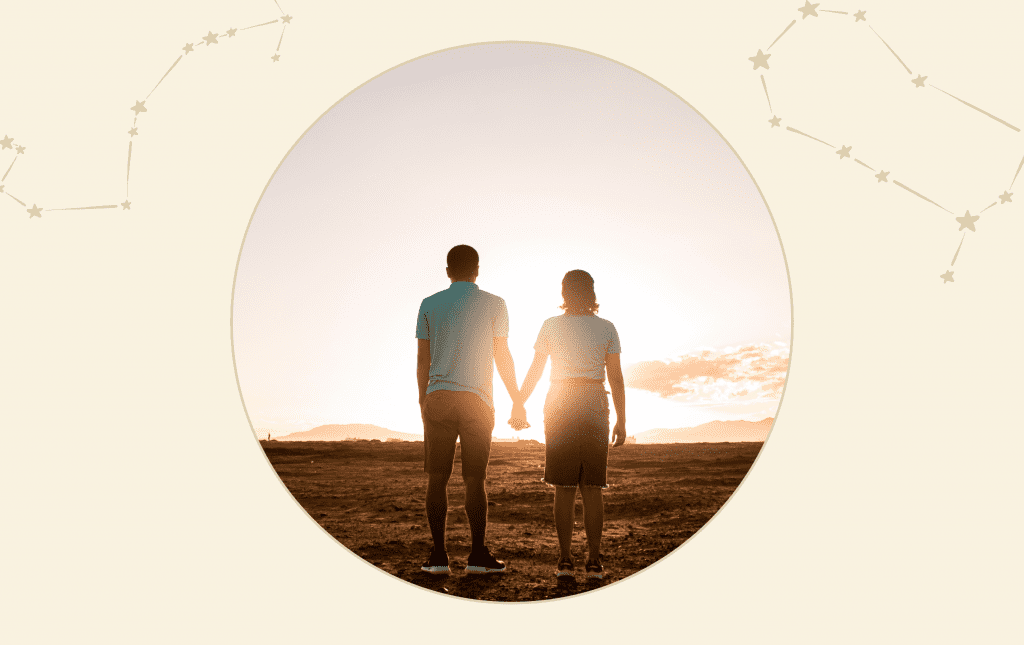 A man and a woman holding hands in front of a sun set.